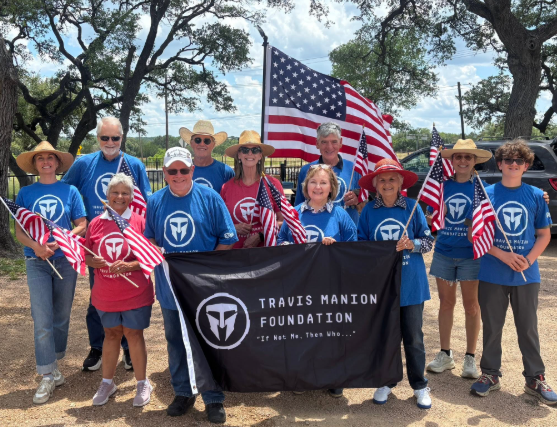 Travis Manion Foundation volunteers holding American flags and their organization banner
